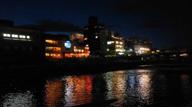 夏の鴨川の夕暮れ時の風情ある納涼床と川面に反射する灯り