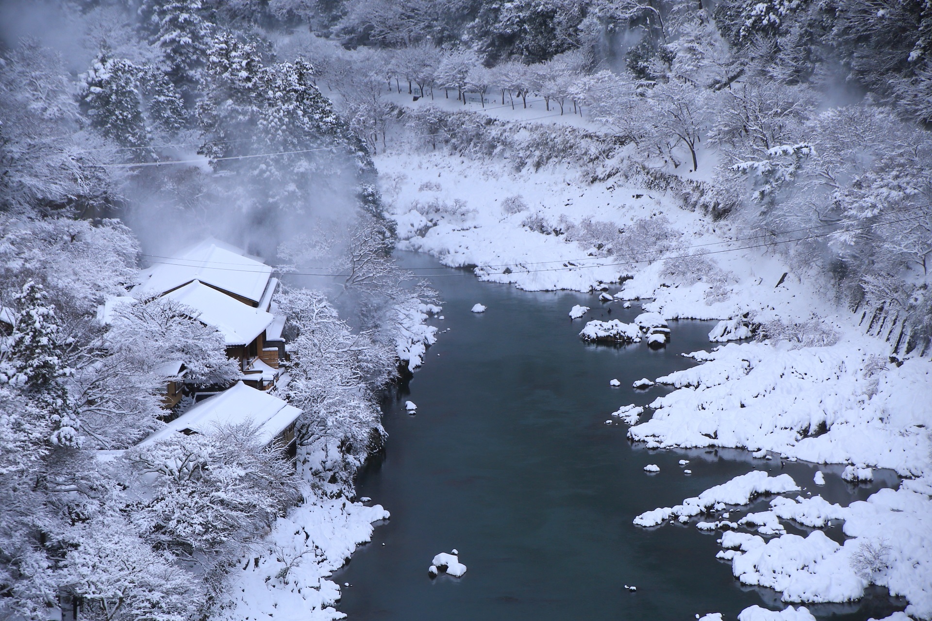真っ白に雪化粧した保津川と川岸