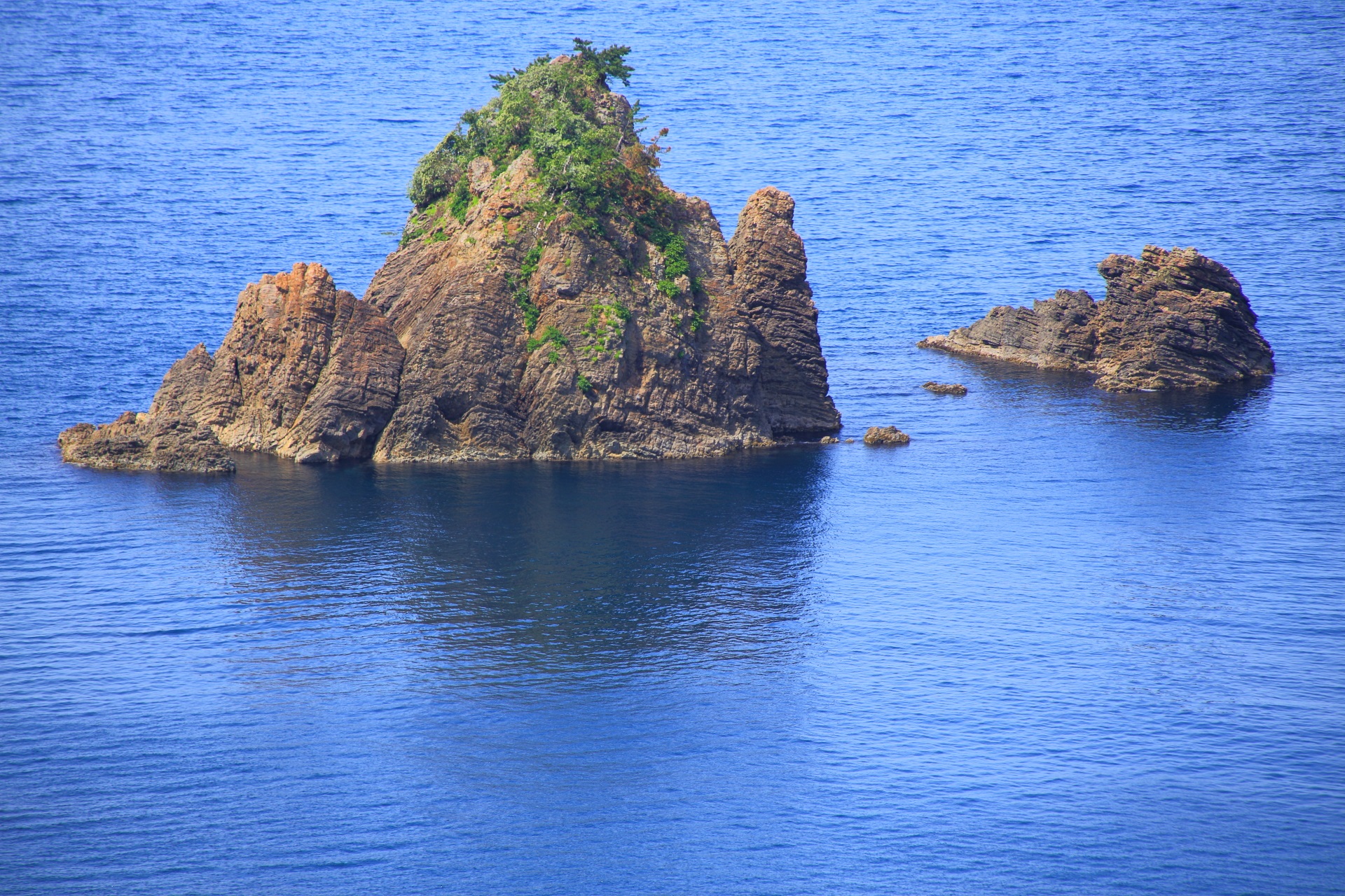力強く緑が育つ海に浮かぶ険しい岩の島