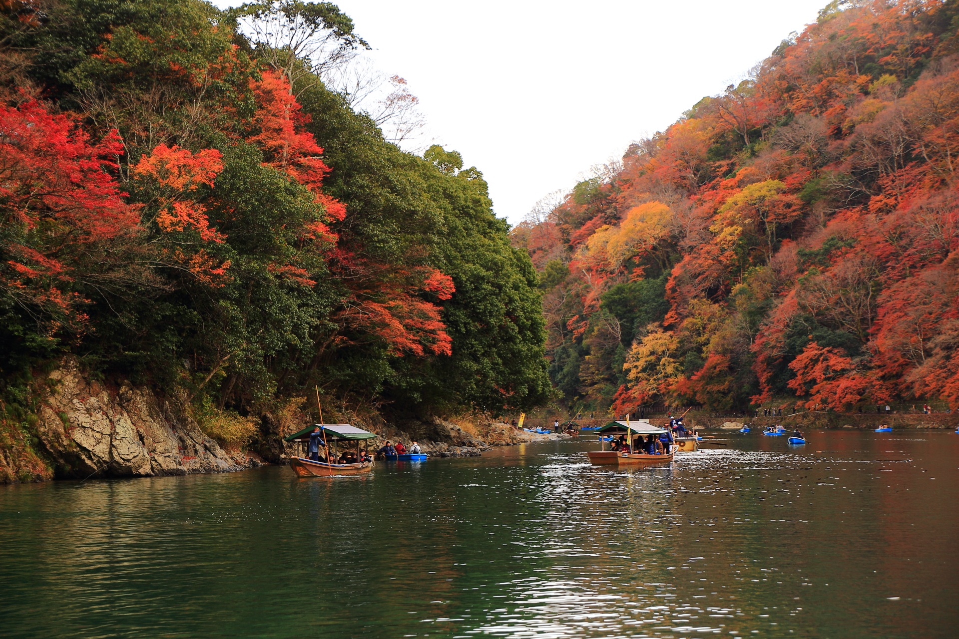 保津川と渡し舟を暖かく染める嵐山の紅葉
